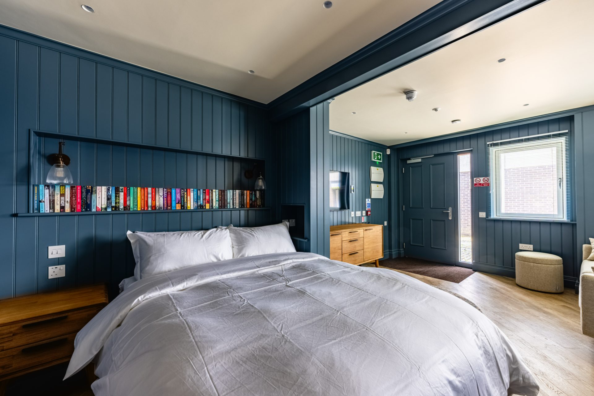 The Stables — navy panelled studio with a built-in bookcase and its own street door