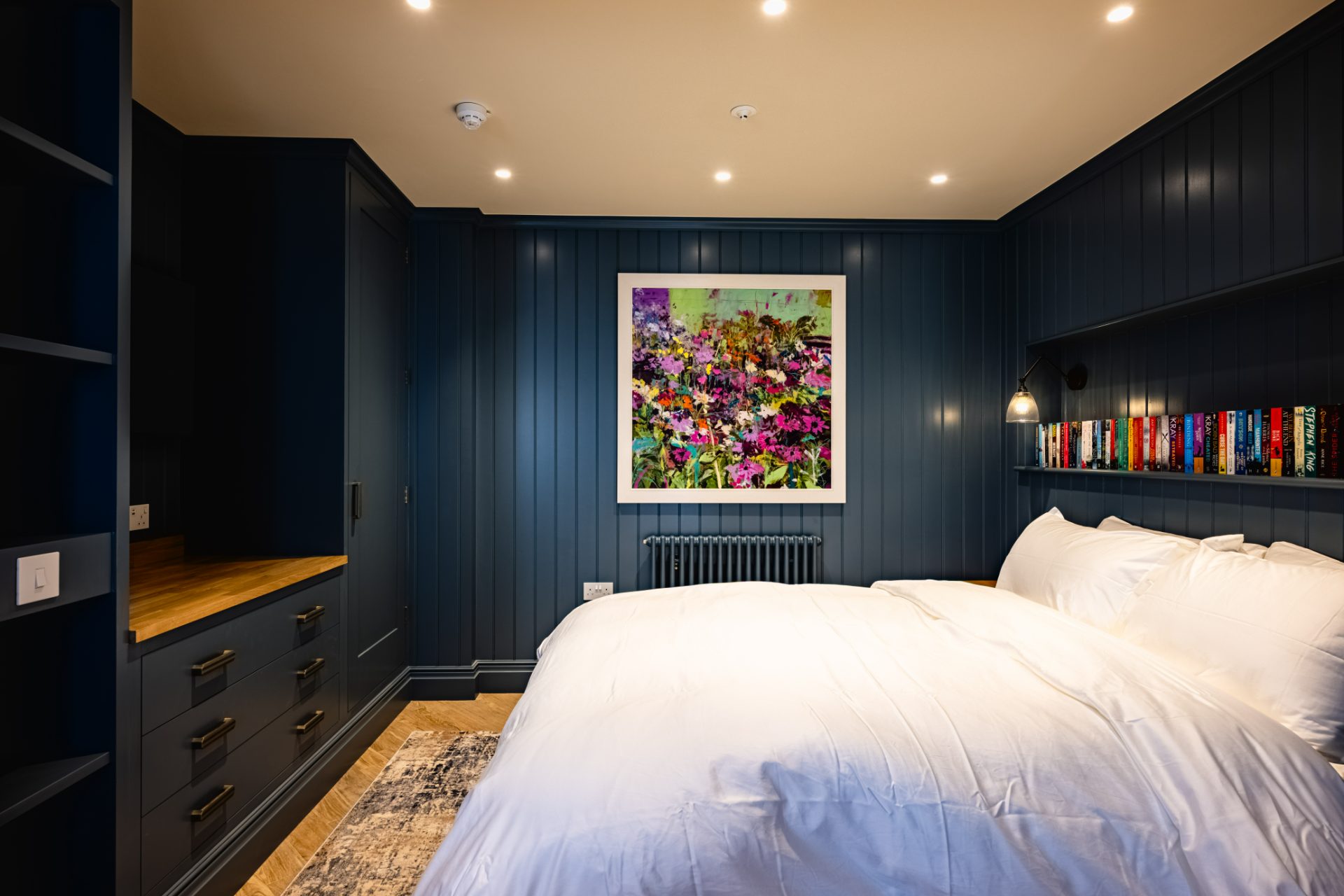 The Stables sleeping area with panelling and artwork