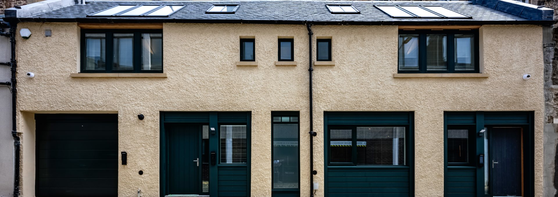 The mews frontage at 22 Young Street North Lane — harled facade, green doors and Edinburgh cobbles